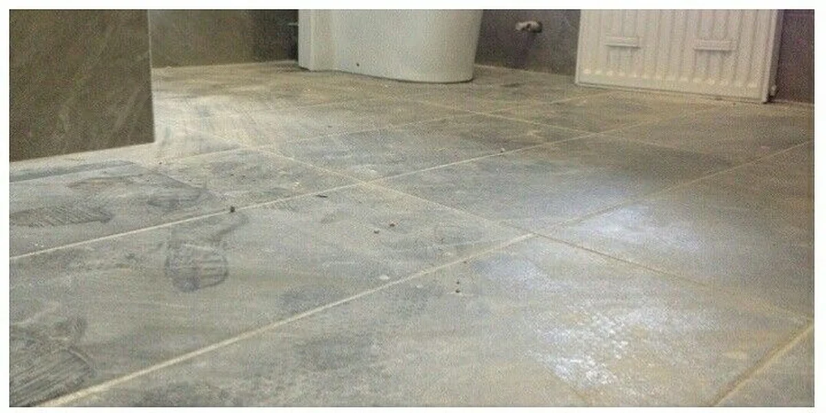 Antes — piso de banheiro com pó de obra e marcas, Dublin